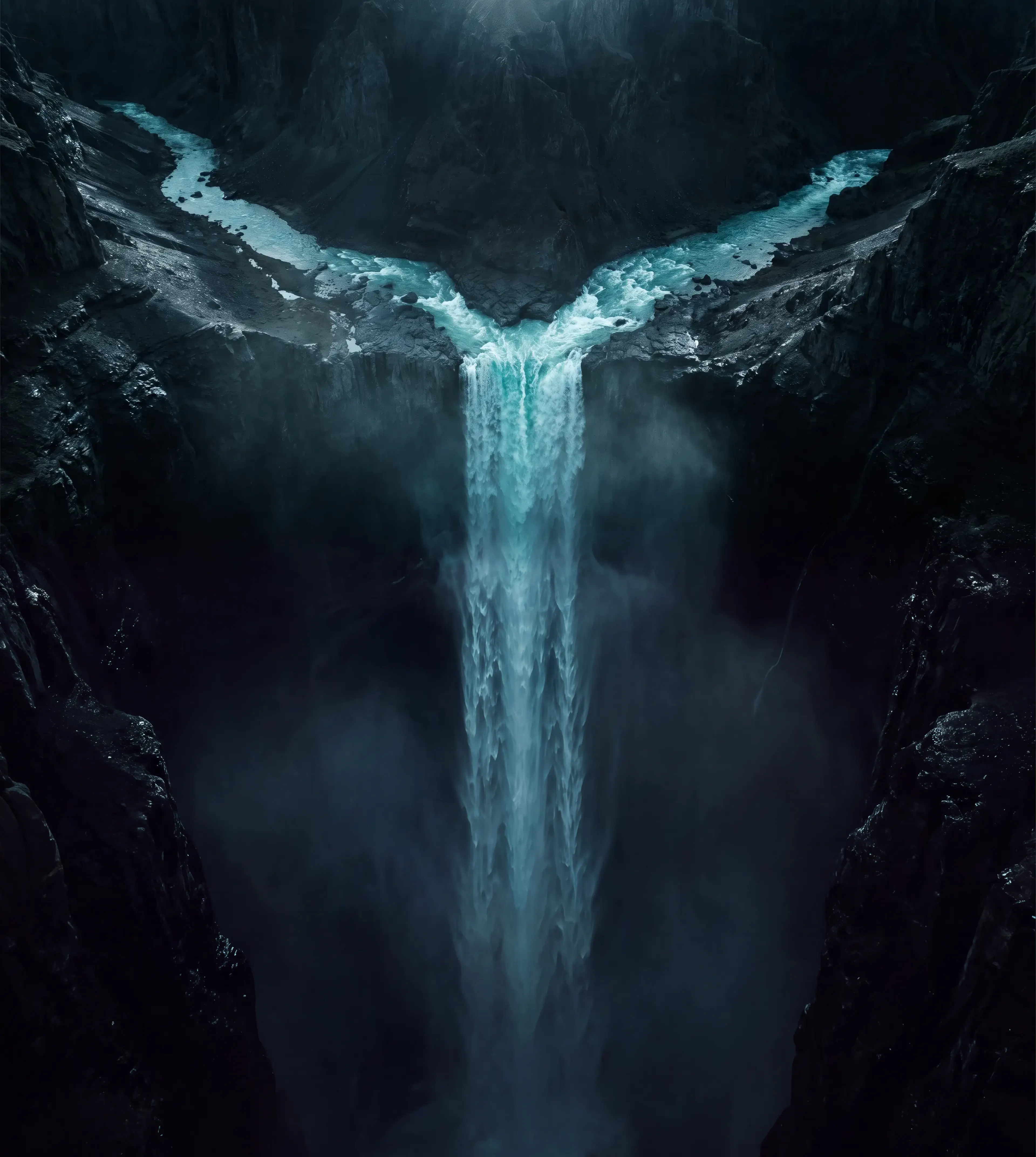 Zwei Fluesse, die sich in einer dunklen Schlucht vereinen und als ein Wasserfall in die Tiefe stuerzen